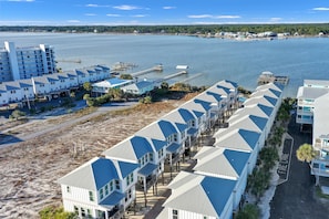 A coastal hotel with multiple buildings, a pier, and a beach area. - Cottages At Lagoon Pass D 2 Bedroom Home (Gulf Shores)