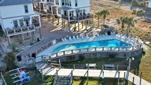 Una propiedad frente a la playa con varias construcciones, una piscina y una terraza de madera.