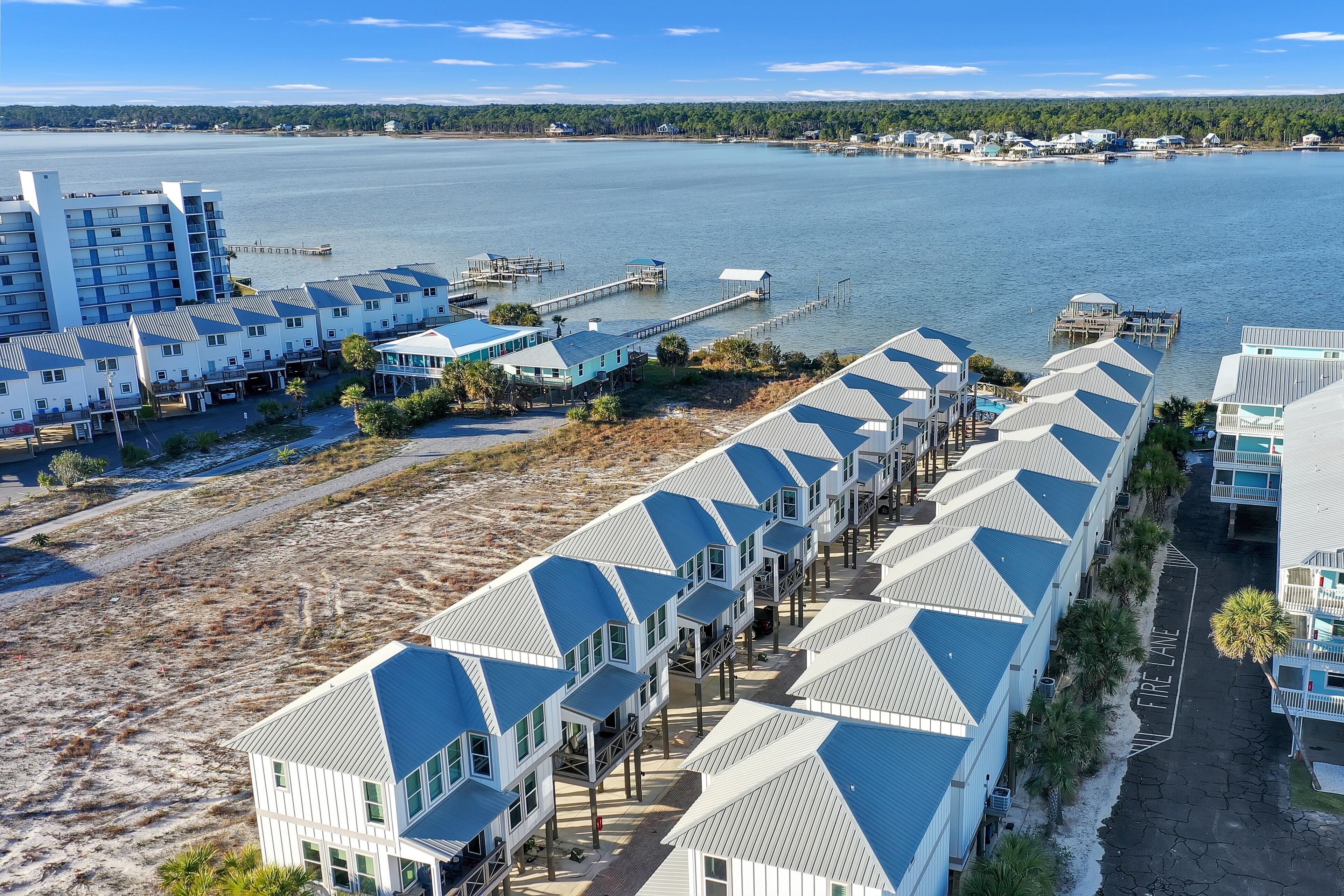 A coastal hotel with multiple buildings, a pier, and a beach area.