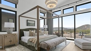 A spacious bedroom with a four-poster bed, large windows, and a view of the countryside. - Mtn Retreat w/ Hot Tub, Game Room & Lake Views (Heber City)
