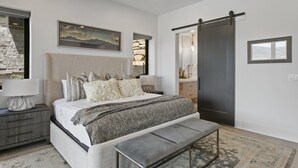 A bedroom with a bed, bedside tables, a bench, a dresser, a mirror, and a painting on the wall. - Mtn Retreat w/ Hot Tub, Game Room & Lake Views (Heber City)