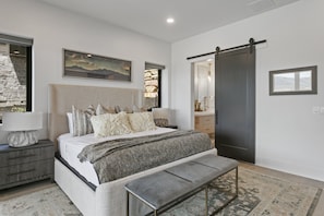 A bedroom with a bed, bedside tables, a bench, a dresser, a mirror, and a painting on the wall. - Mtn Retreat w/ Hot Tub, Game Room & Lake Views (Heber City)