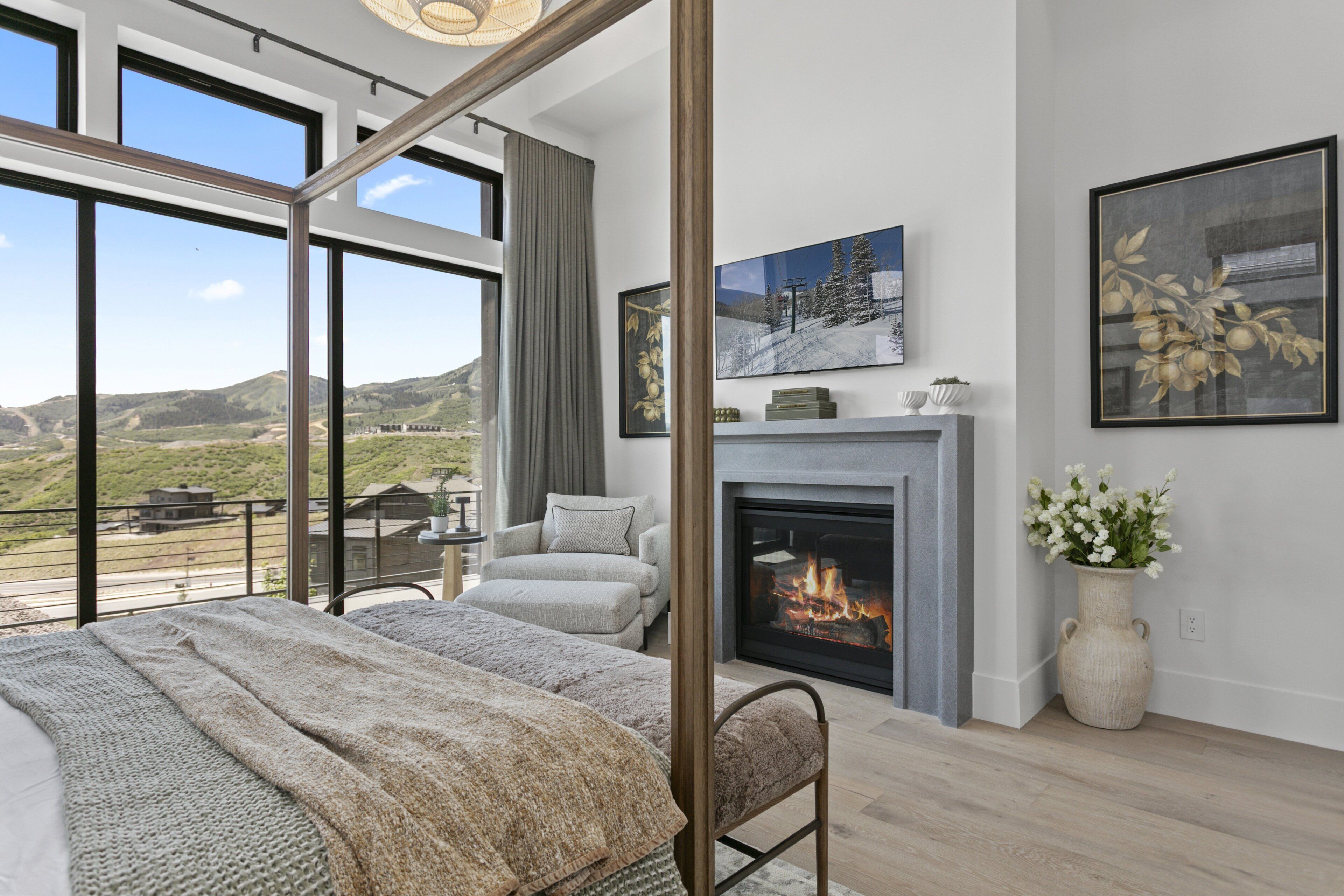 Una habitación amplia con un gran ventanal, una chimenea y una cama con vistas al exterior.