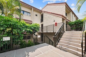 A residential building with a stone facade, a gated entrance, and a staircase leading to the entrance. - Big Island Keauhou Punahele C202 2 Bedroom Condo (Kailua-Kona)