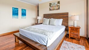 A bedroom with a bed, bedside tables, a ceiling fan, and artwork on the walls. - Big Island Keauhou Punahele C202 2 Bedroom Condo (Kailua-Kona)