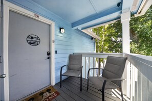A porch with two chairs, a door with a 'Home Sweet Home' sign, and a window with a view of trees. - "Your Happy Place" Close To All The Magic! 3 Bedroom Condo (Kissimmee)