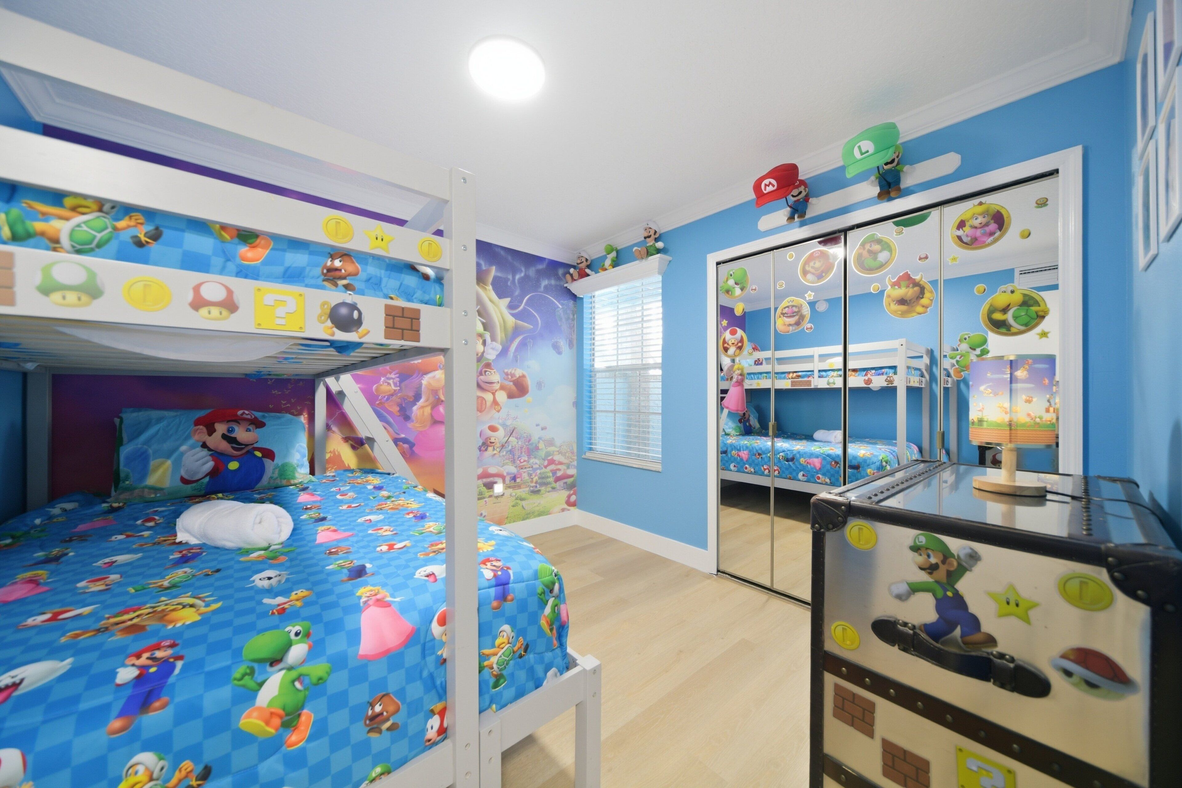 A children's room with bunk beds, a wardrobe, and wall decals.