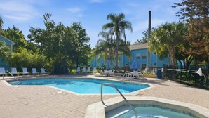 A swimming pool with a tiled deck, surrounded by lounge chairs and palm trees. - "castle Retreat" Close To All The Magic! 3 Bedroom Condo (Kissimmee)