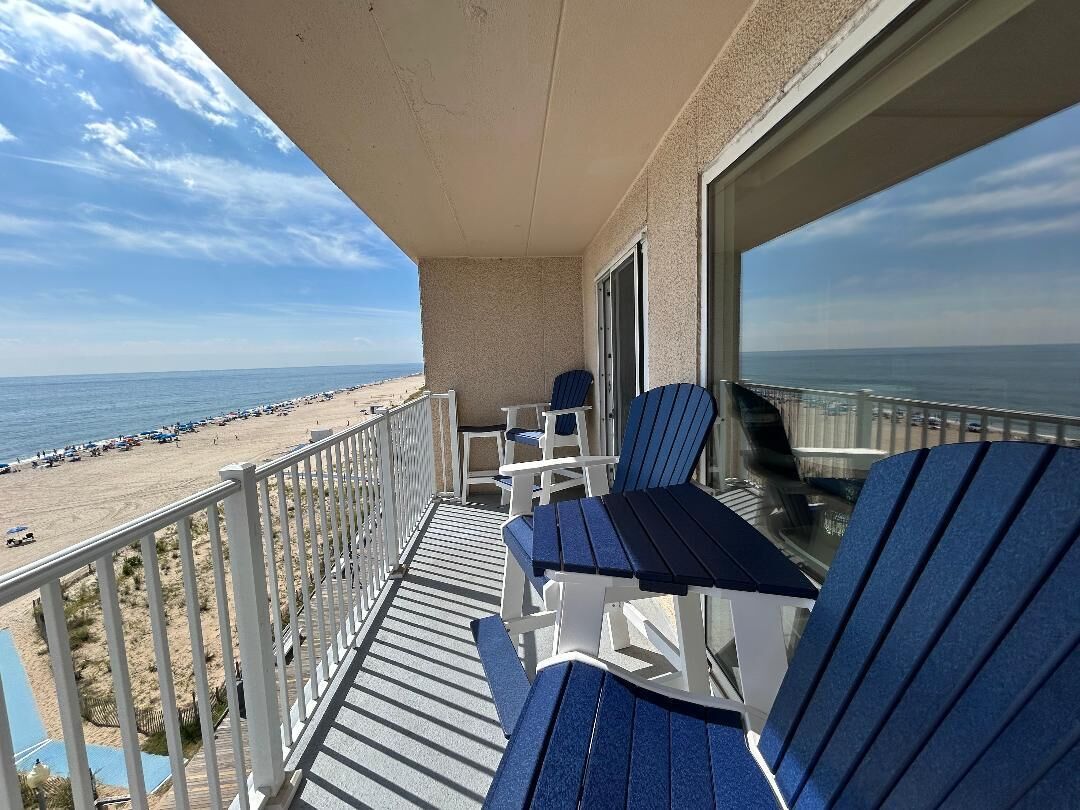 A balcony with a view of the beach and ocean.