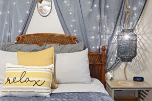A bedroom with a bed, pillows, a bedside table, a lamp, and a wall-mounted clock. - Single-story Navarre home sleeping 9 across 4 bedrooms, just minutes from sugar-white Navarre Beach. Full kitchen, in-unit laundry, workspace, and a beach bag stocked with towels & life jackets. Perfect for an easy Gulf Coast family escape! (Navarre)