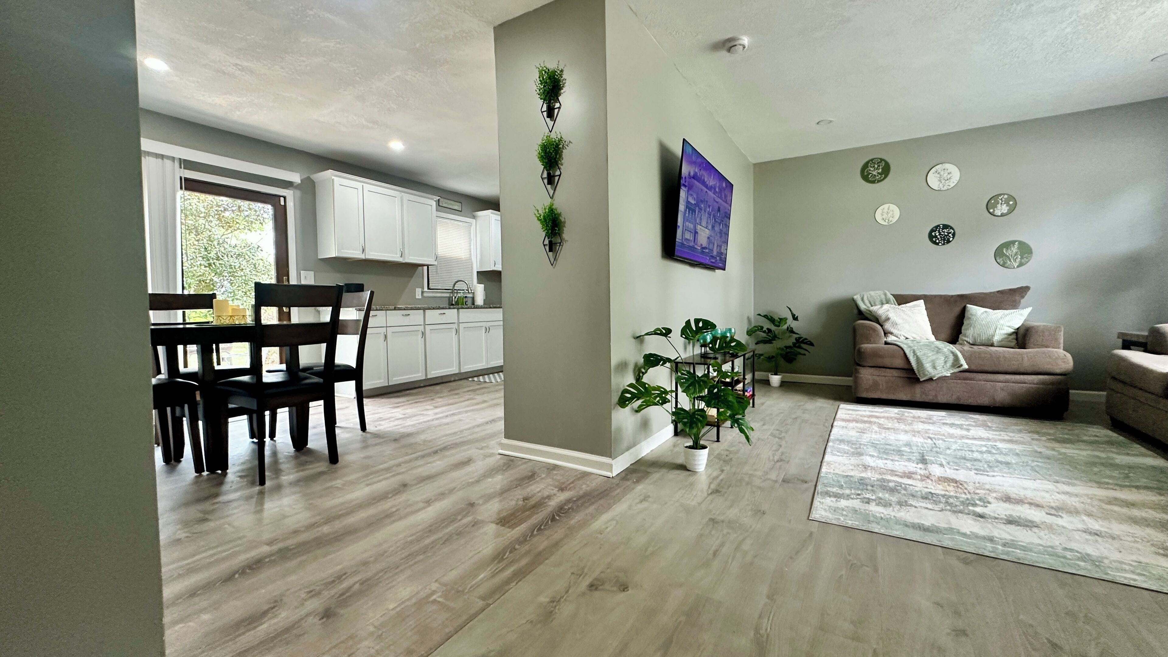 A modern living space with a dining area, kitchen, and seating area.