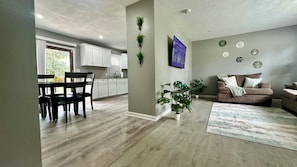Un espacio de estar moderno con comedor, cocina y zona de descanso.