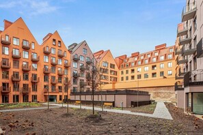 A residential building with multiple floors, balconies, and a landscaped courtyard. - Granaria B104 | TOP Location (Gdańsk)
