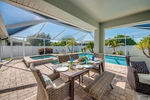 Outdoor dining - Blue Heaven Rendezvous — 4 BR/ 2 bath retreat in SW Cape Coral with  heated pool and spa, bicycles, and fully fenced backyard (Cape Coral)