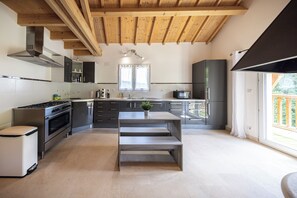 A modern kitchen with a central island, stainless steel appliances, and a wooden ceiling. - Large house for 12 people with 2 vacation apartments - 220 m² - 10 beds (Meurthe-et-Moselle)