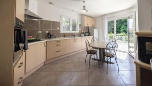 Una cocina moderna con comedor, ventanas amplias y chimenea.