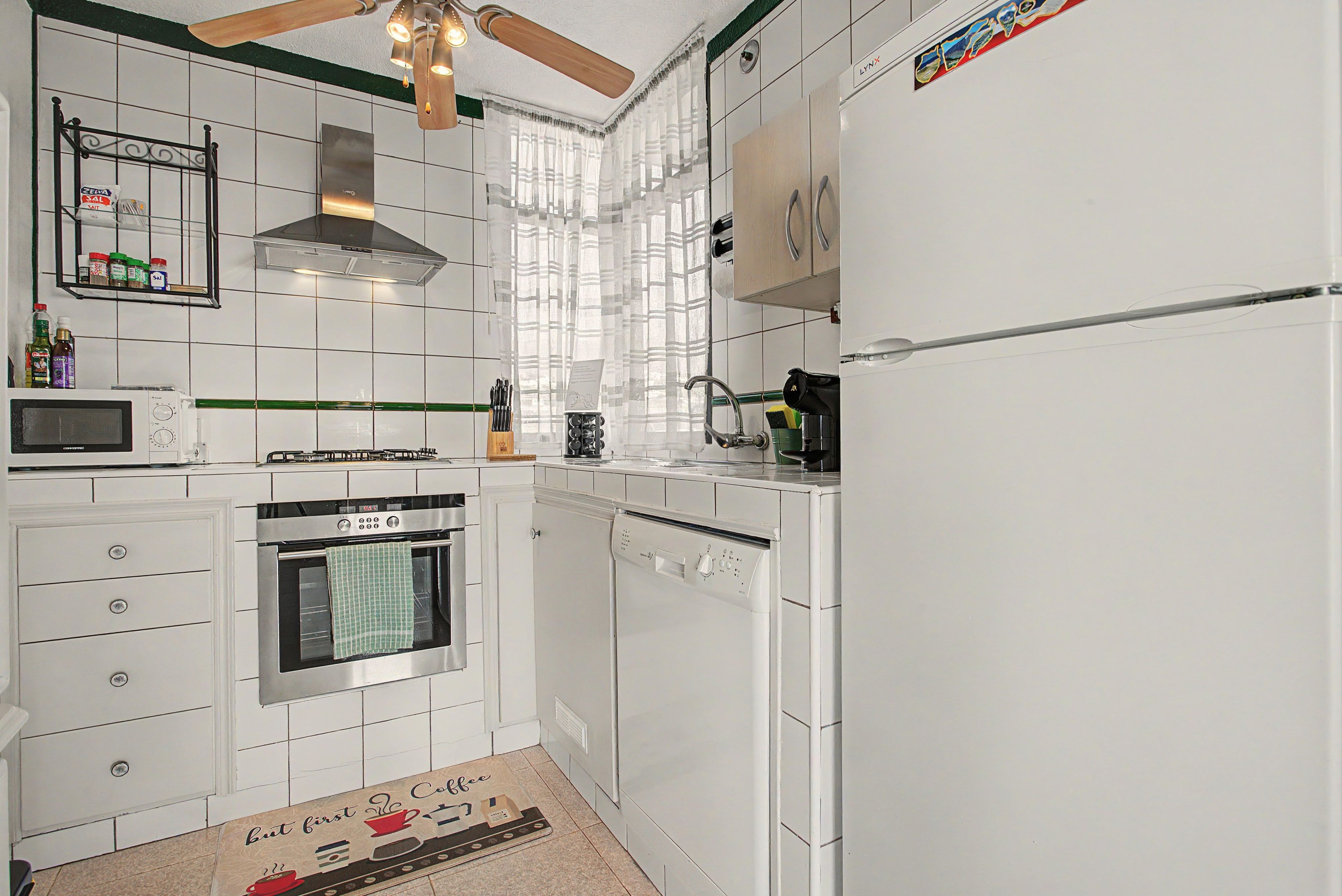 A kitchen with white cabinets, a microwave, an oven, a dishwasher, and a gas stove.