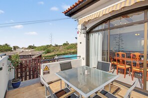 A glass table with chairs on a balcony with a view of the surrounding area. - Vacation Home 'Casa Colina Tenerife' with Sea View, Balcony and Wi-Fi (Granadilla de Abona)