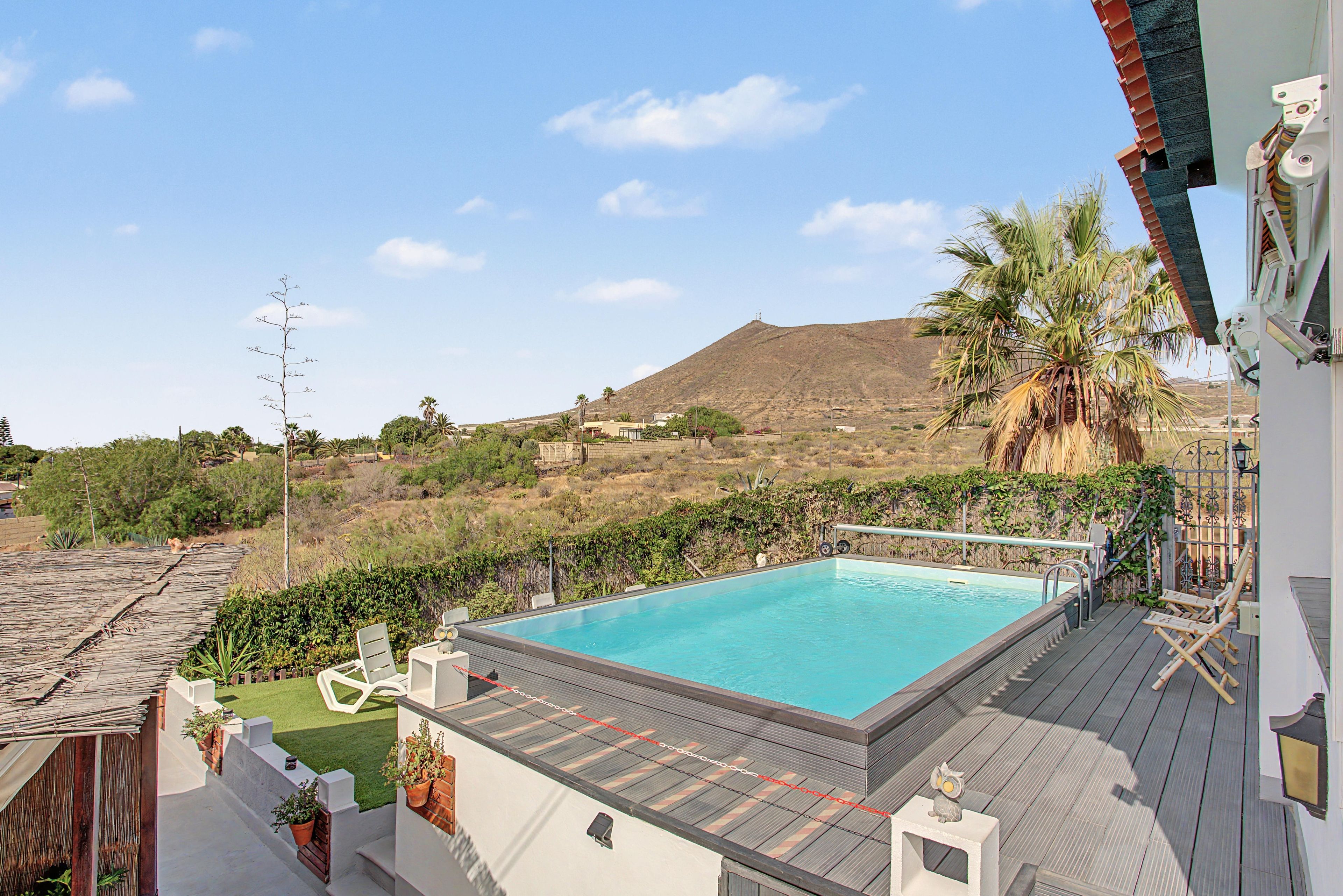 A swimming pool with a view of a mountain and a clear sky.