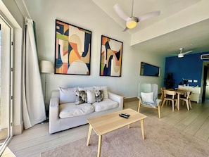 A living room with a sofa, coffee table, and artwork on the wall. - Gold Coast Luxury Sea View, High-End Amenities (Punta Cana)
