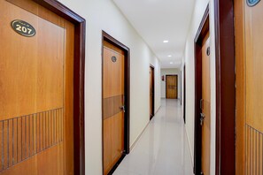 Ein Hotelgang mit Holztüren, jede mit einer Nummer versehen.
