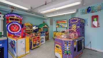 Um quarto com vários jogos de fliperama, incluindo uma máquina de prêmios 'Roll for Gold' e um jogo 'Ticket Eater'.