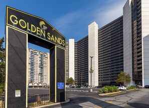 Un grand bâtiment dont l’entrée est marquée par une enseigne indiquant « GOLDEN SANDS ».