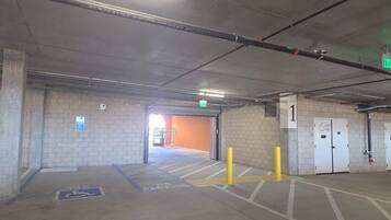 A parking garage with a wheelchair-accessible space marked, a fire exit, and a level indicator.