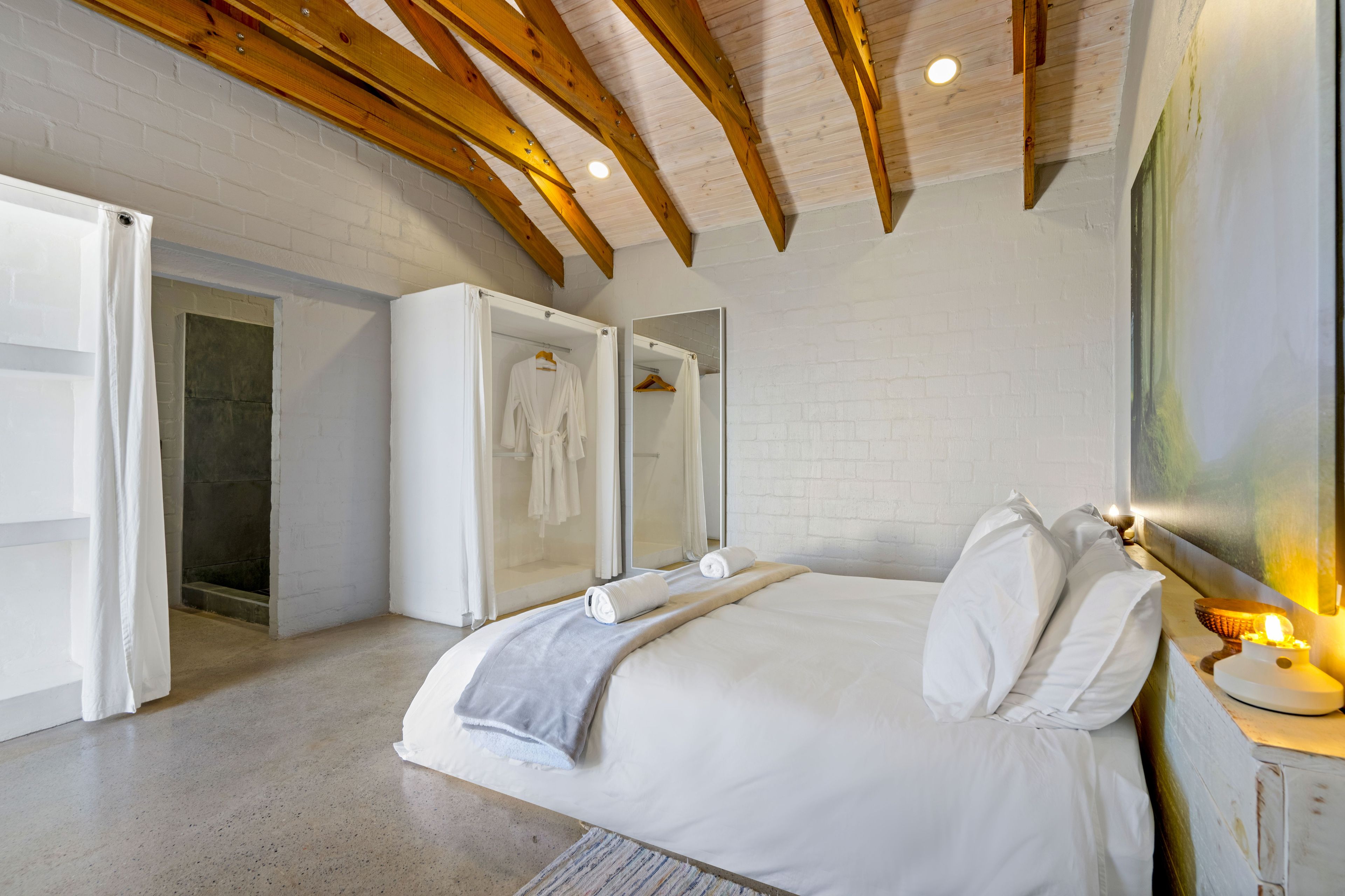 Une chambre à coucher avec un lit, un dressing et une douche.