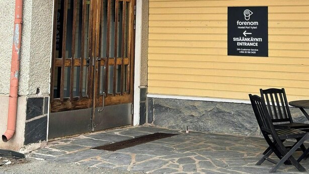 A hostel entrance with a sign indicating 24-hour customer service.