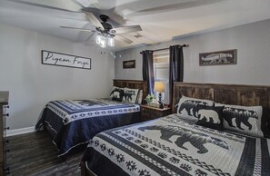 Ein Schlafzimmer mit zwei Betten, einem Deckenventilator und einem Schild mit der Aufschrift 'Pigeon Forge'.
