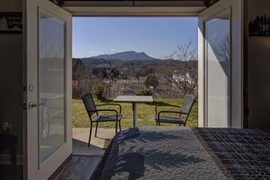 Ein Schlafzimmer mit einem Bett und zwei Stühlen vor einer Bergkulisse.