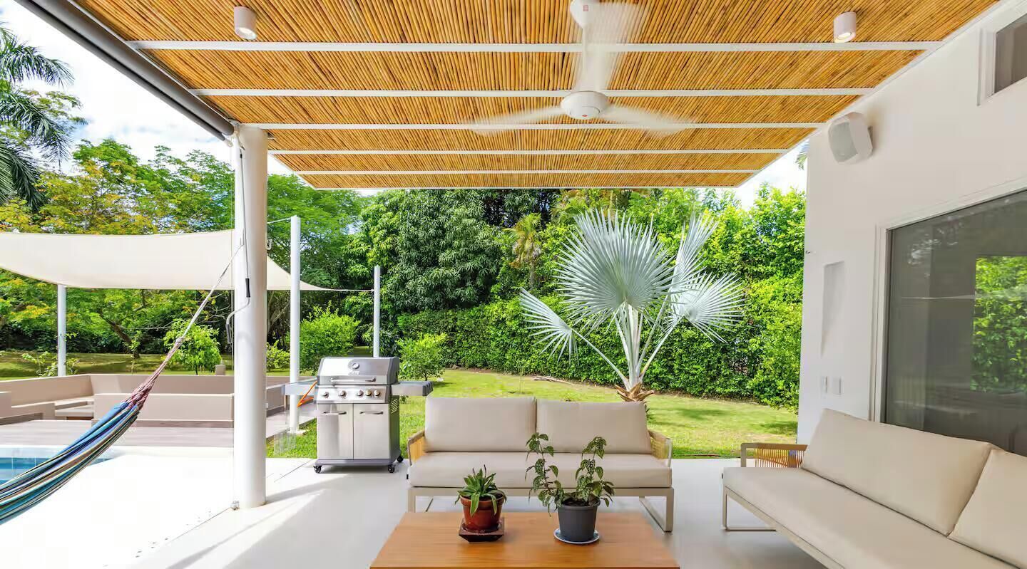 Un espace extérieur aménagé avec un barbecue, des sièges et une vue sur le jardin.