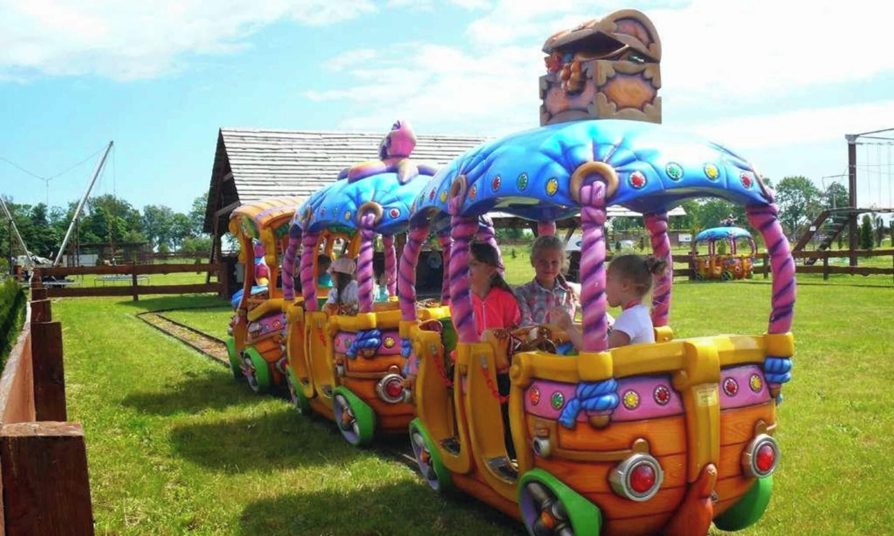 Een kleurrijke treinrit met kinderen die binnen zitten.