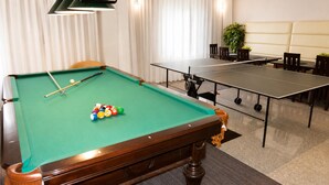 A pool table with balls and cues, a ping pong table, and a seating area with chairs and a table. - Holiday Homes Near the sea (Kamien Pomorski)