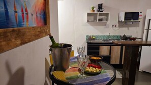 Eine Küche mit einem Esstisch, gedeckt mit einer Flasche, Gläsern und Snacks.