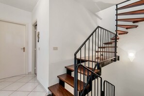 Eine Treppe mit Holzbodenstufen und schwarzen Metallgeländern.