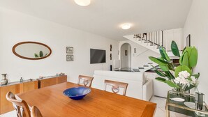 A modern dining area with a wooden table, chairs, and a blue bowl. There is a staircase leading to an upper level. - [RoadToTheSea]Lerici/Private parking /terrace (Lerici)