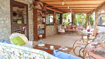 A cozy living area with a sofa, chairs, a bookshelf, and a dining table.