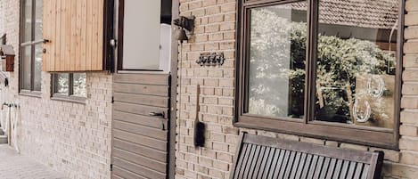 A brick building with a wooden bench and a door.
