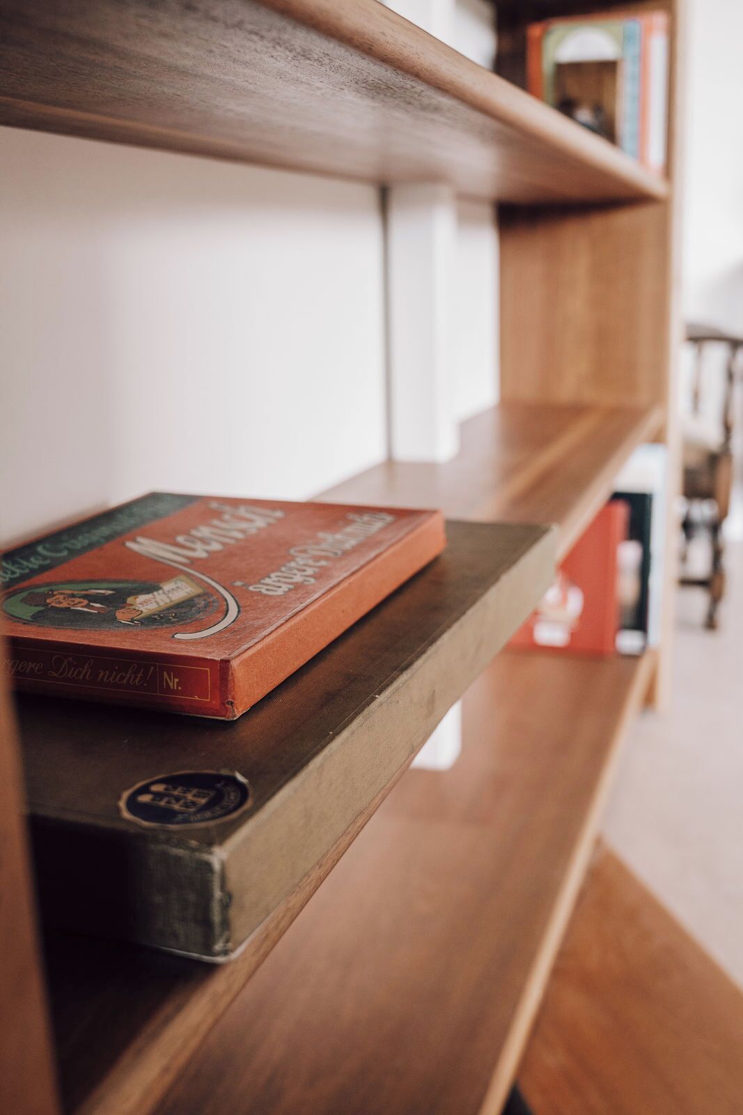 A bookshelf with books and a wooden shelf.