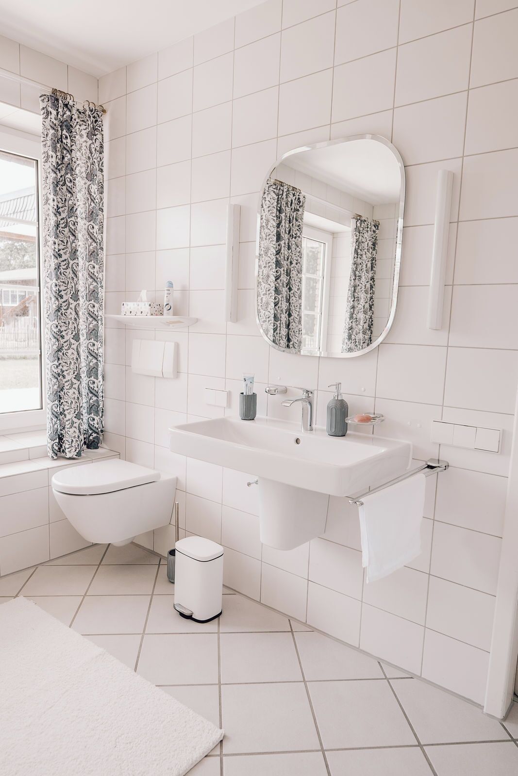 Ein modernes Badezimmer mit Toilette, Waschbecken und Spiegel.