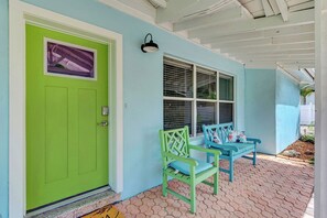 A house with a green door, a covered porch, and two blue chairs. - Private pool, Next to the island and downtown- The best of both worlds (Sarasota)