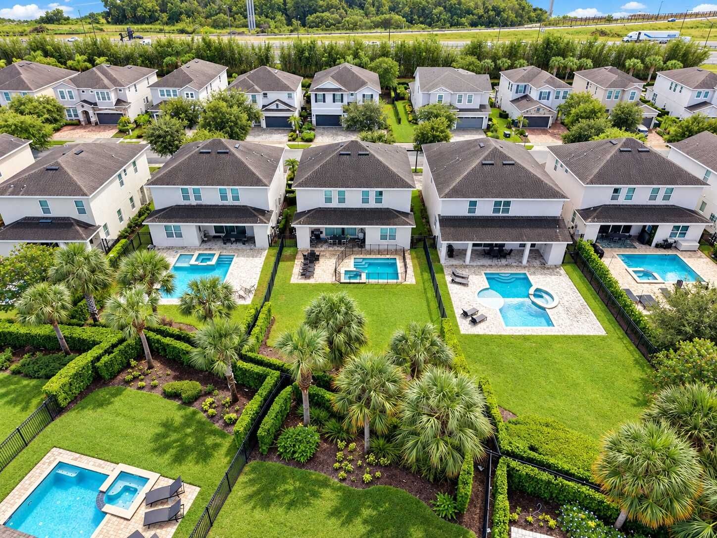 A residential area with multiple houses, each with a swimming pool and well-maintained lawns.