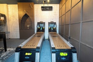 A bowling alley with two lanes, a brick wall, and a chandelier. - Pool, Spa & Game Room Home for 12 at Encore (Kissimmee)