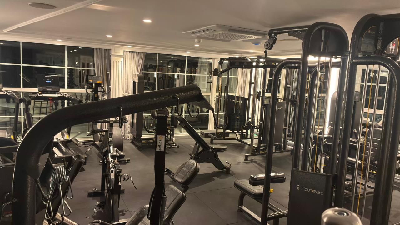 Un gimnasio con diversos equipos de ejercicio, incluyendo cintas de correr y máquinas de pesas.