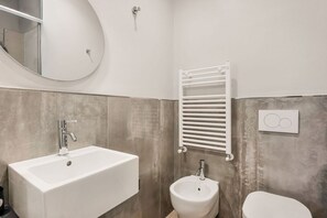A bathroom with a rectangular sink, a bidet, a toilet, a towel rack, and a mirror. - [Rooms Camera2] 5Terre-Near the station+A/C (La Spezia)