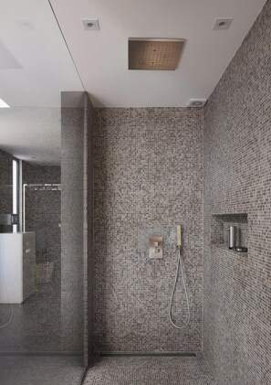 A modern shower with a mosaic tile wall, a handheld showerhead, and a control panel.