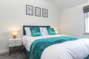A bedroom with a bed, two bedside tables, a window with curtains, and three framed artworks on the wall. - The Waltons – Ideal Durham Escape - Nature Lovers - Pass the Keys (New Brancepeth)