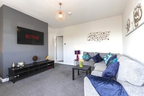 A living room with a flat-screen TV, a sofa, a coffee table, and decorative items. - The Waltons – Ideal Durham Escape - Nature Lovers - Pass the Keys (New Brancepeth)